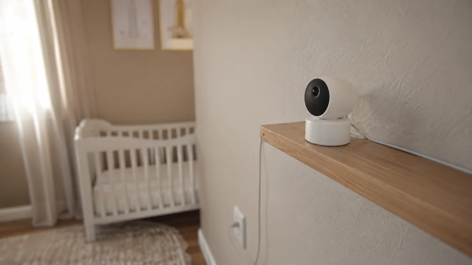 Câmera Wi-Fi motorizada instalada em prateleira de quarto de bebê, com berço desfocado ao fundo