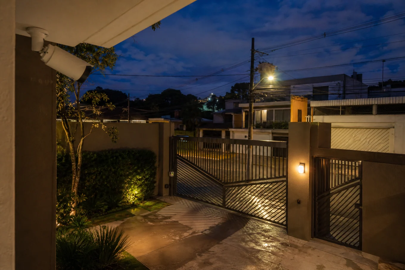 Garagem e portão residencial monitorados por câmera externa durante a noite