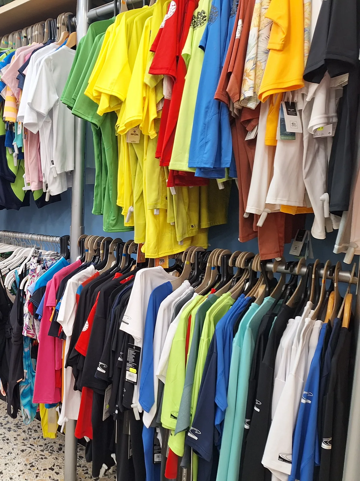 Araras com roupas coloridas penduradas em uma loja de varejo