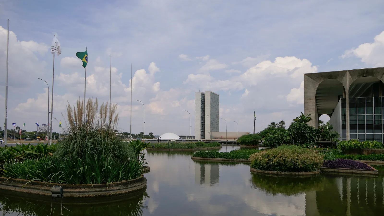 Torres gêmeas do Congresso Nacional refletidas em espelho d'água, com o Palácio do Itamaraty ao fundo