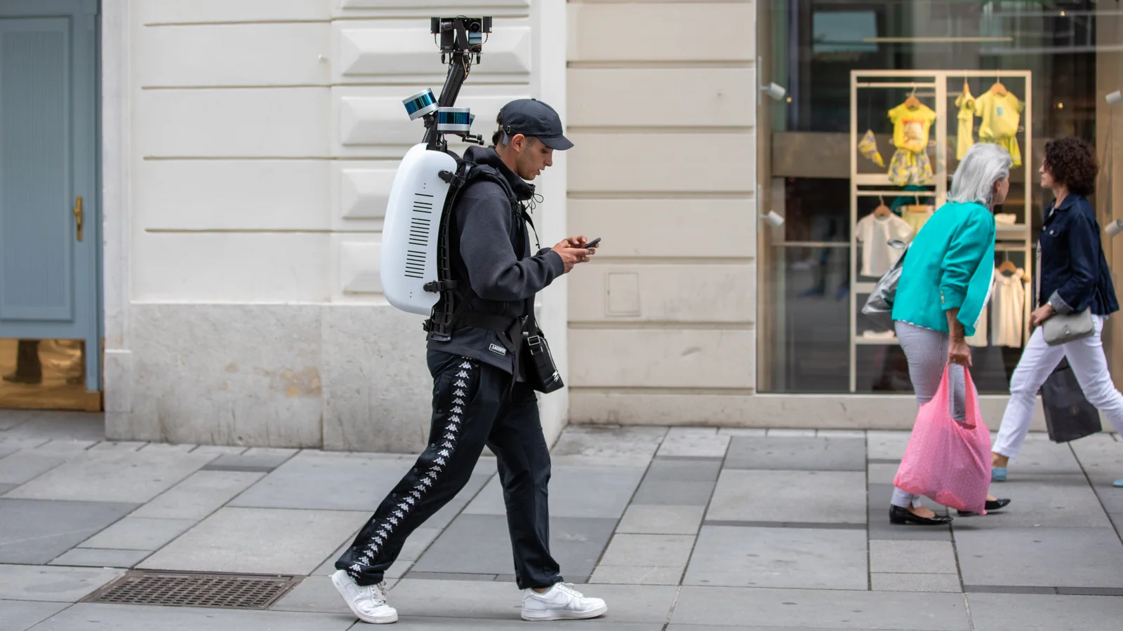 Operador caminha por uma rua de Viena usando mochila com câmeras do Apple Maps