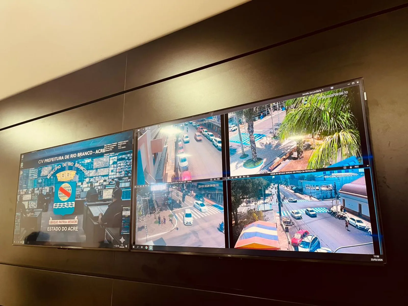Parede de telas com o logotipo CIV Prefeitura de Rio Branco - Acre à esquerda e imagens de câmeras de trânsito ao vivo à direita, com operadores trabalhando ao fundo