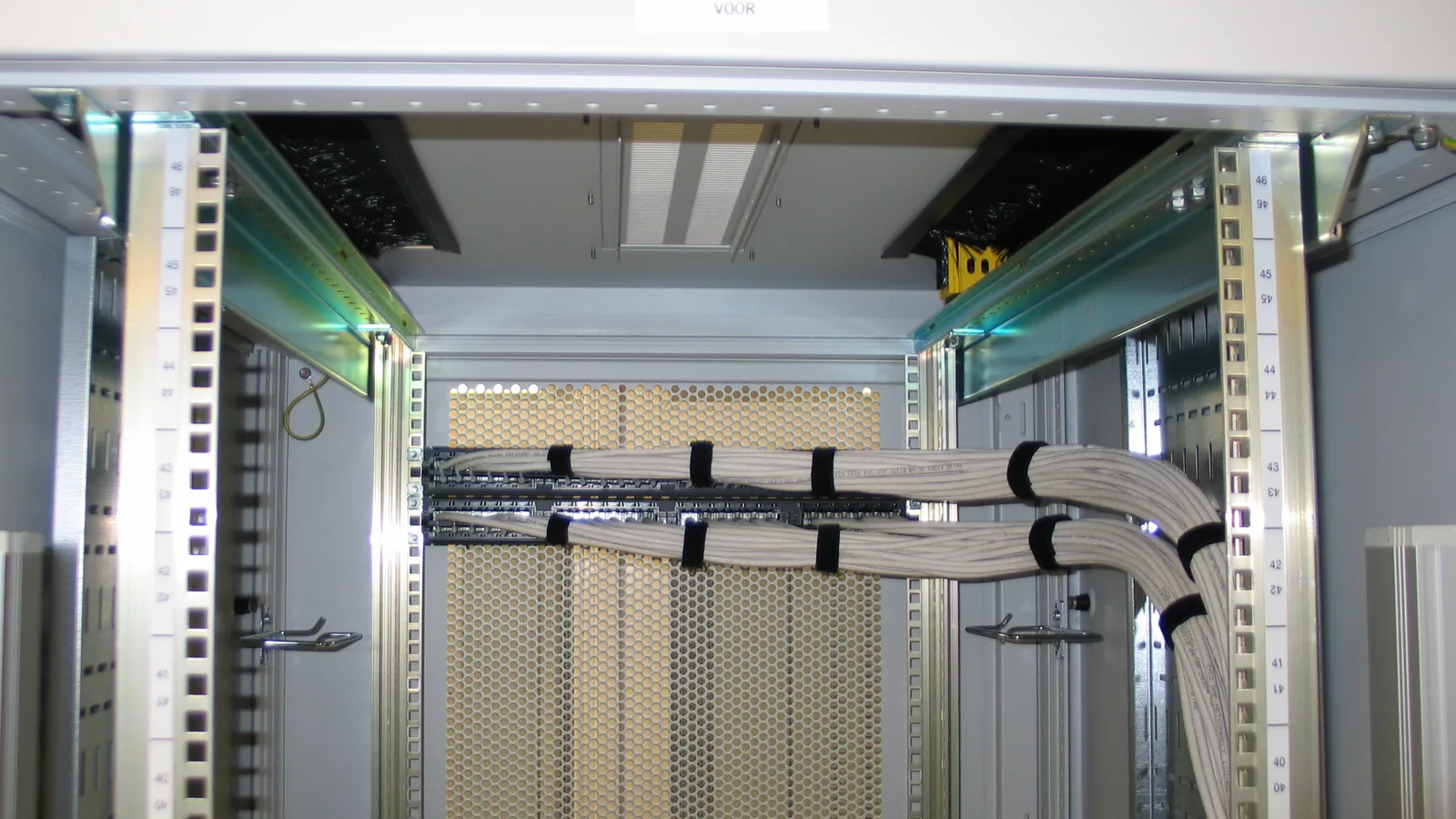 Rack de servidores com cabos de rede organizados, em uma sala de equipamentos